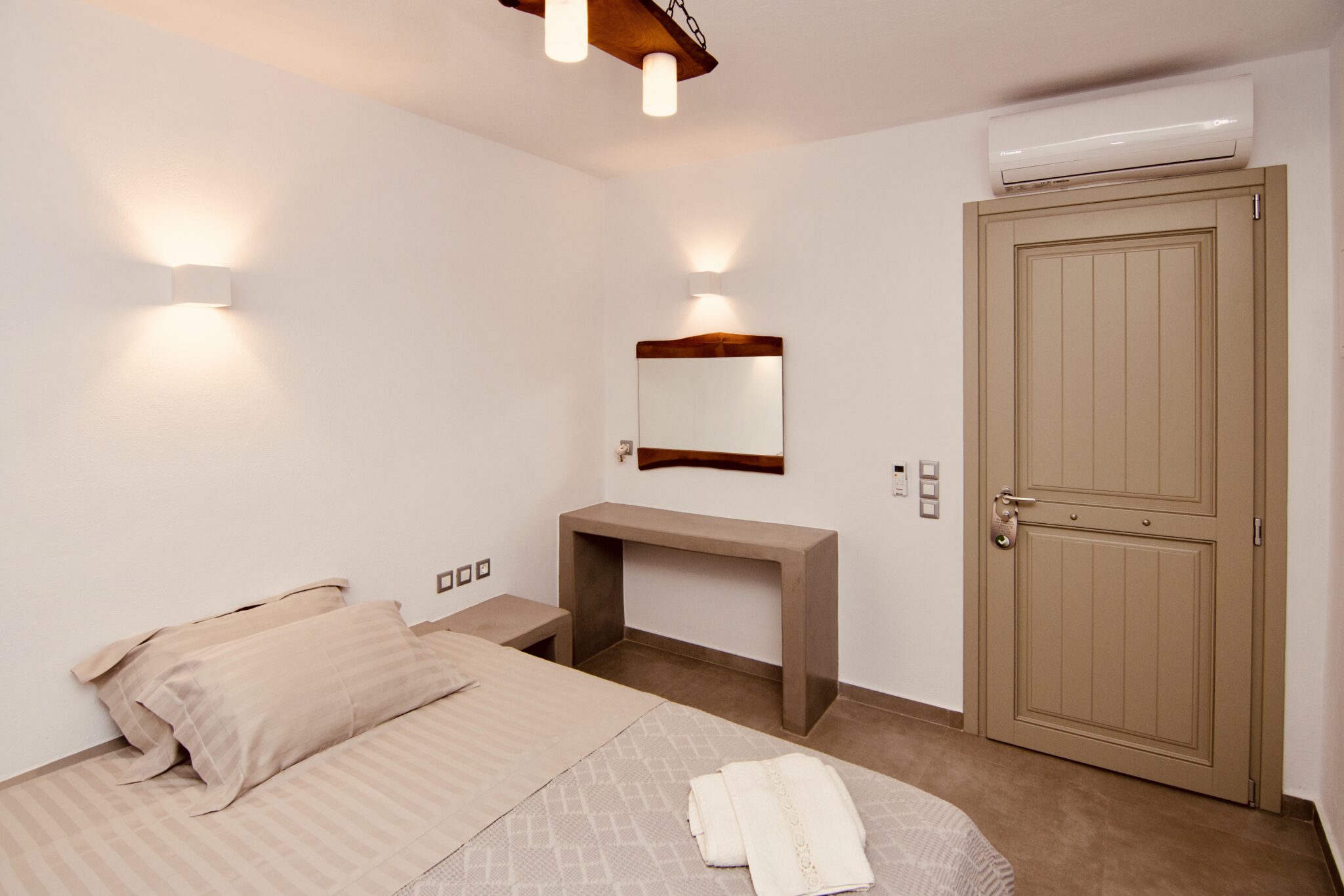 Apartment in Chora, Aeris Suites – bedroom with built-in desk and warm lighting