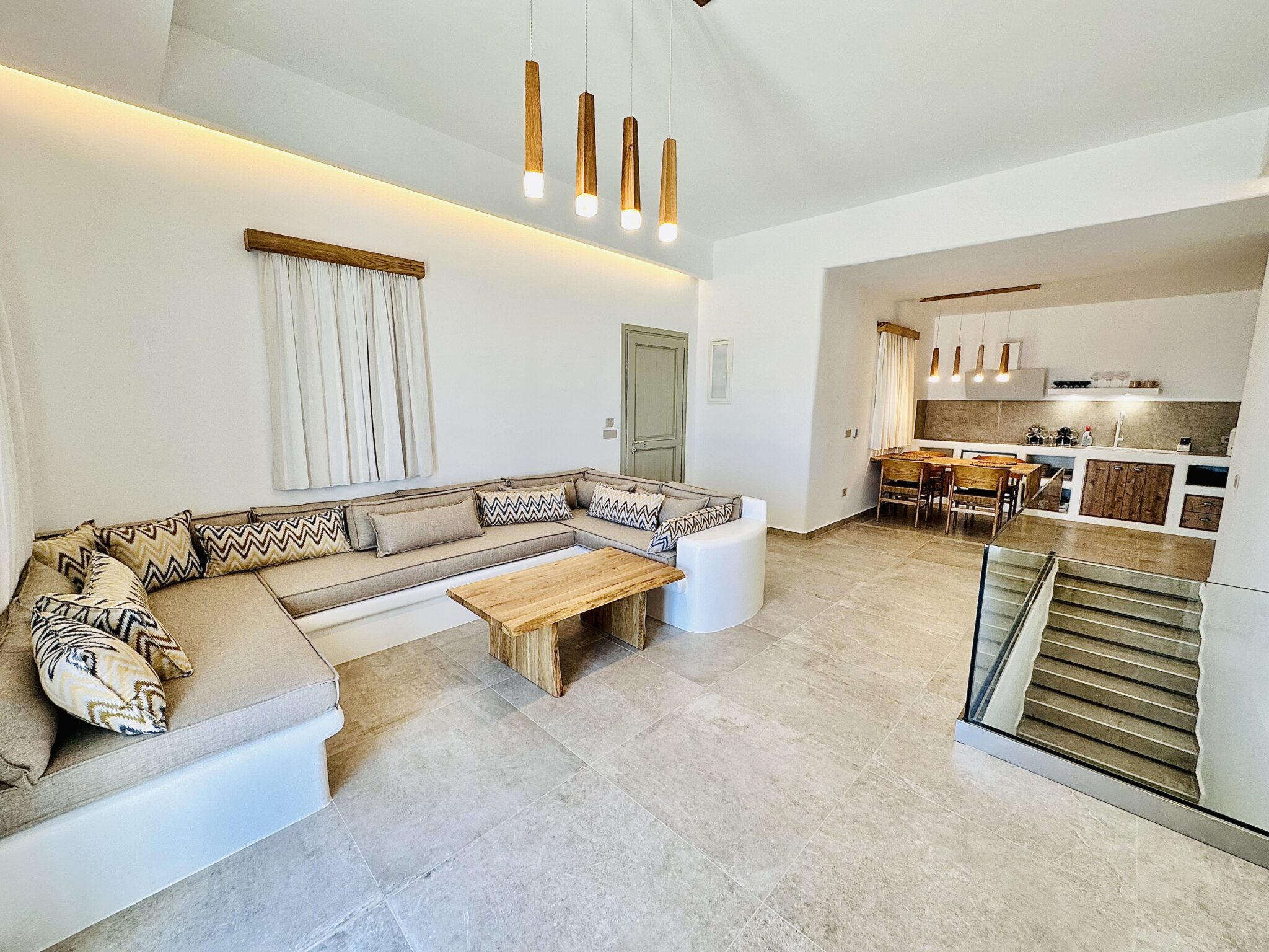 Villa with Private Pool & Jacuzzi – open-plan living room with built-in sofa and dining area